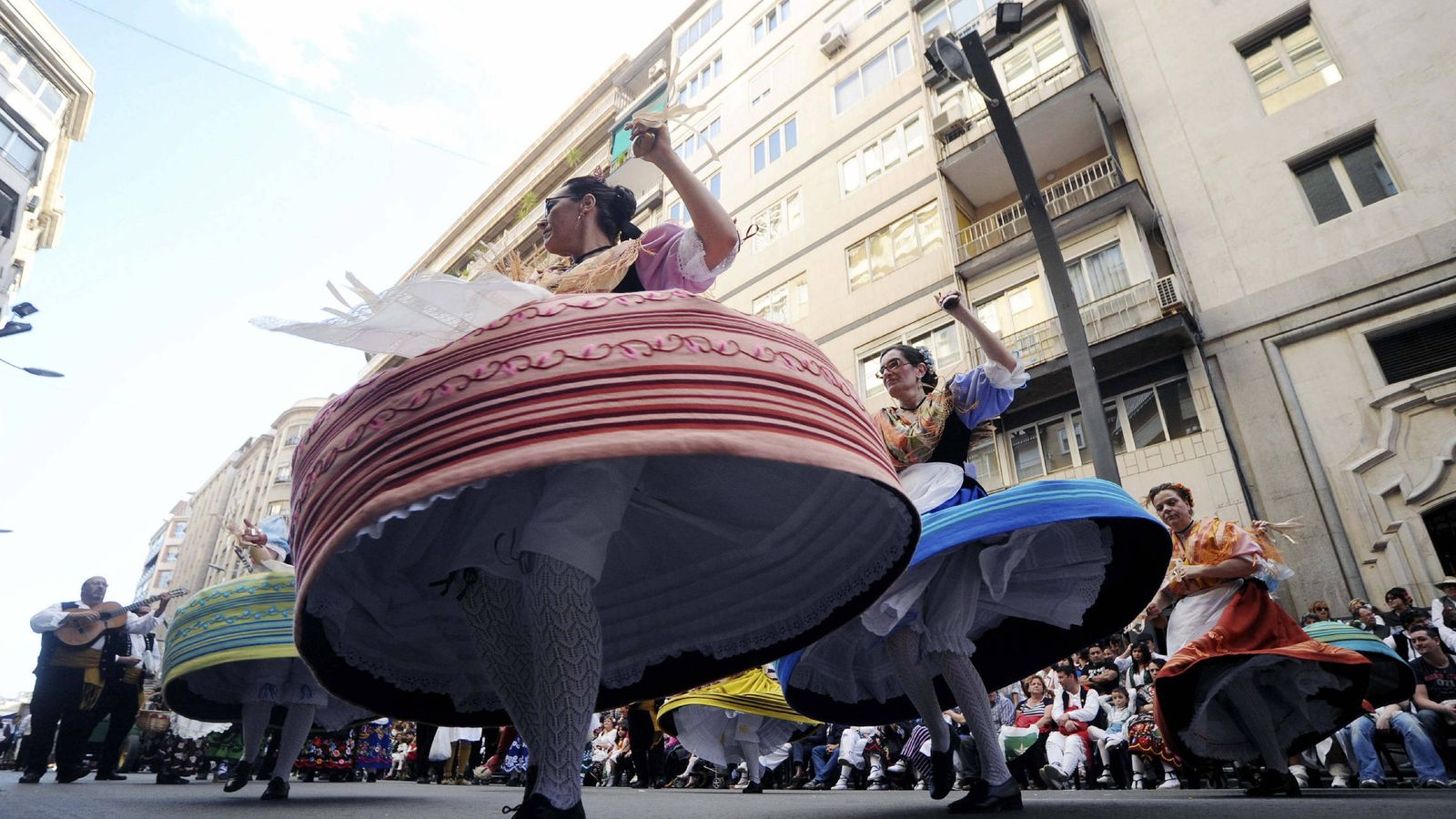 Foto: Varias jóvenes bailan en la calle en el desfile del Bando de la Huerta de Murcia. (EFE)