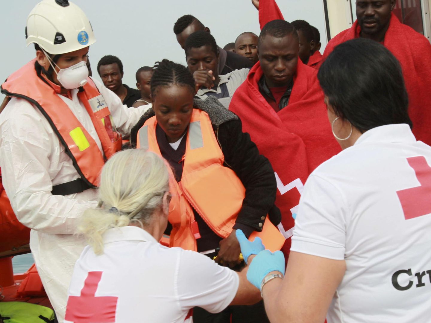 Empleados de Cruz Roja ayudan a desembarcar a inmigrantes subsaharianos. (EFE)