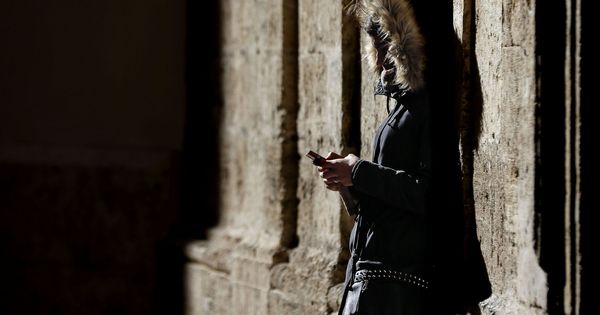 Foto: Una joven consulta su móvil en Valencia. (EFE)