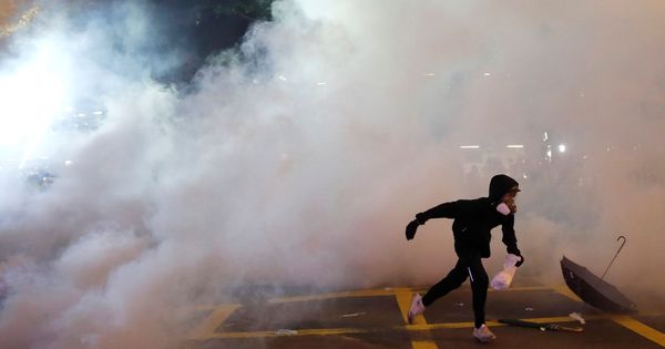 Foto: Un manifestante escapa de la nube de gas lacrimógeno. (Reuters)