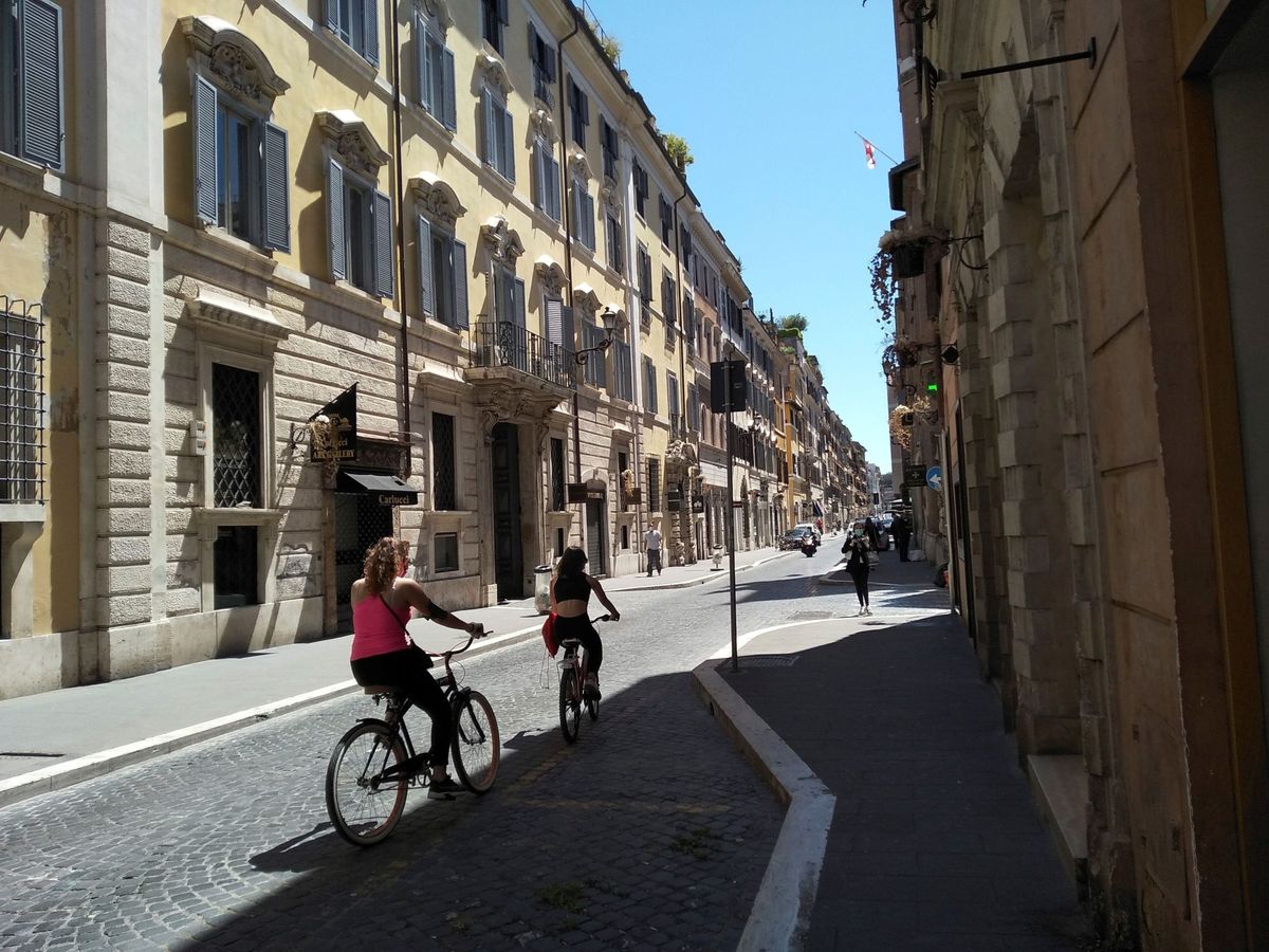 Foto: Dos mujeres usan la bicicleta para desplazarse por las calles de Roma (EFE)