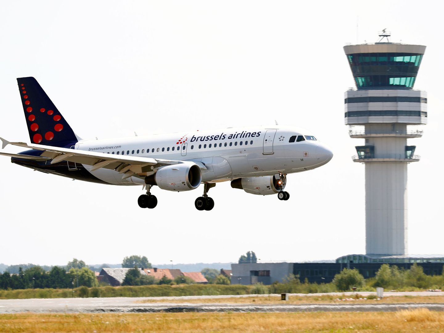 Avión aterrizando en una pista cercana a la torre de control del aeropuerto de Bruselas. (Reuters)