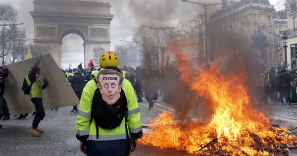 Foto: Un manifestante ante una barricada en llamas durante las protestas de los chalecos en París. (Reuters) 