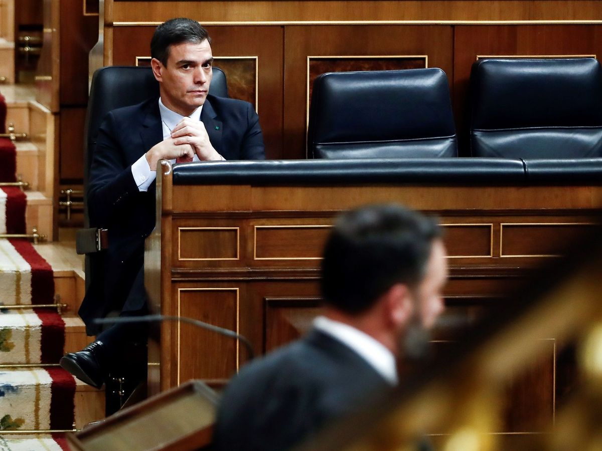 Foto: El presidente del Gobierno, Pedro Sánchez, en su escaño, mientras Santiago Abascal pronuncia su discurso en la tribuna del Congreso. (EFE)