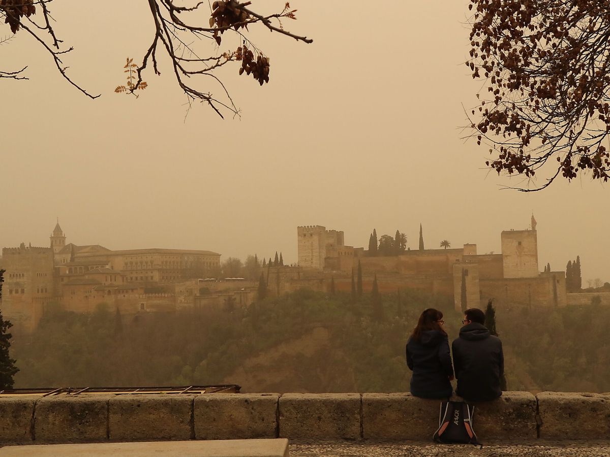 Foto: Dos personas observan la Alhambra de Granada desde el mirador de San Nicolás. (EFE/Pepe Torres)