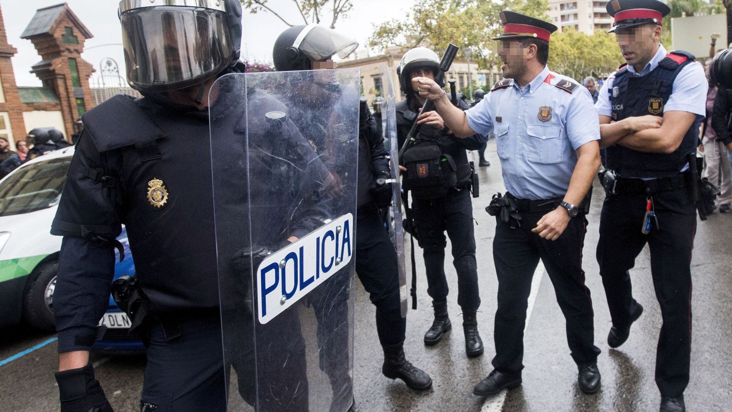 Agentes antidisturbios de la Policía Nacional y de los Mossos d'Esquadra discuten el 1 de octubre. (EFE)