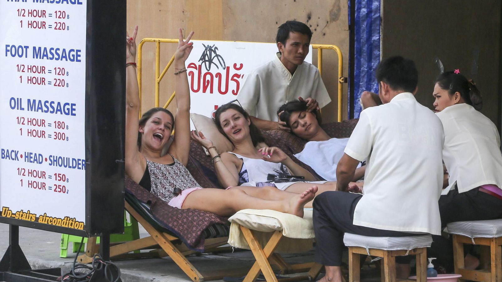 Foto: Turistas disfrutan de un masaje en una calle en Bangkok, Tailandia (EFE)