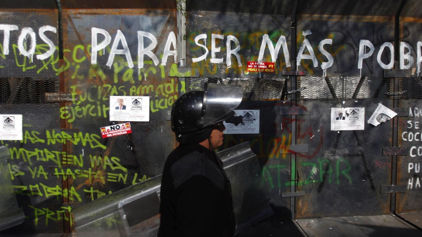 Un agente antidisturbios frente a una valla para proteger el Senado en México D.F. (Reuters)