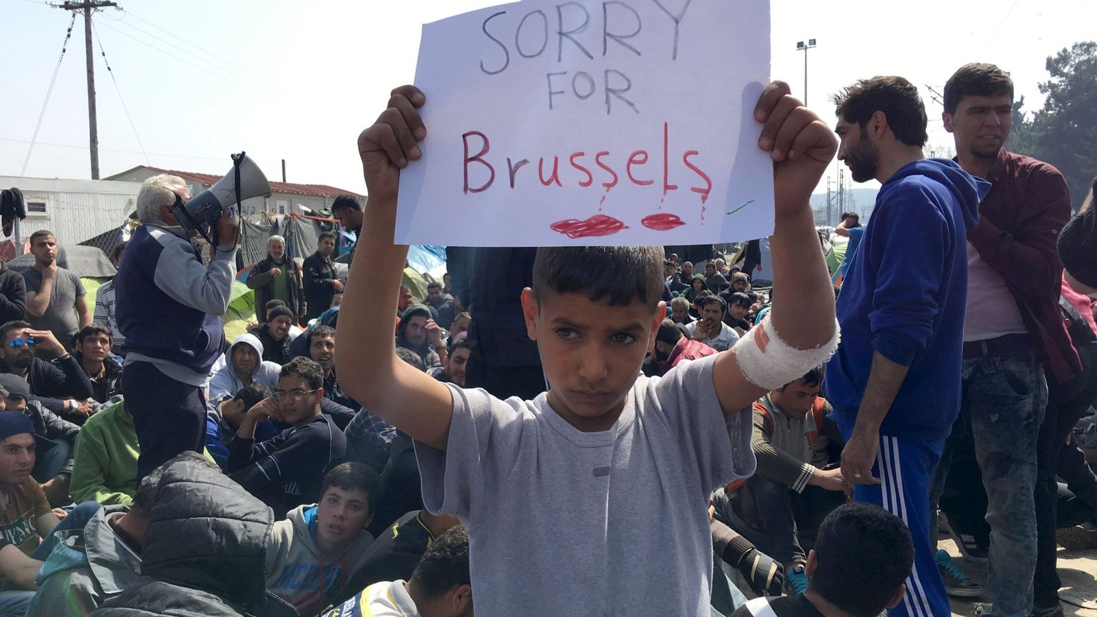 Foto: Un niño refugiado muestra un cartel expresando sus condolencias por el atentado de Bruselas (Reuters)