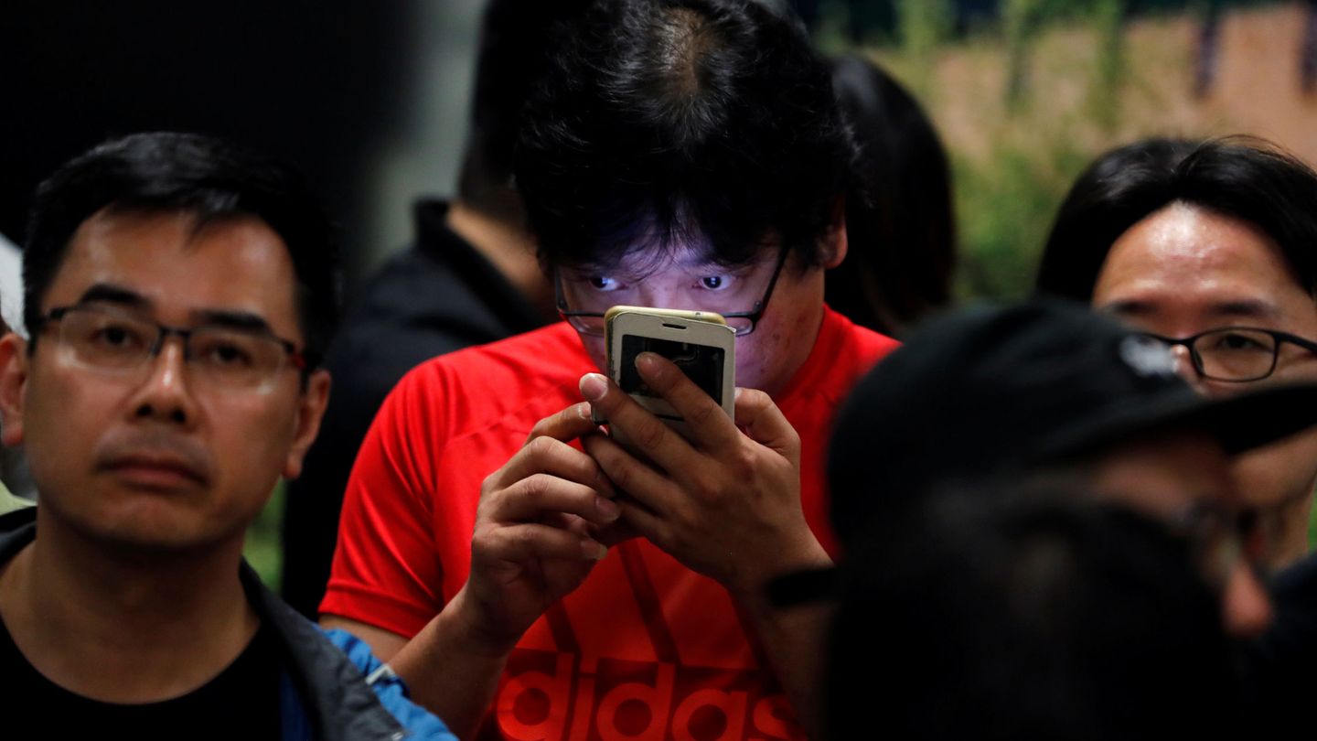 Un ciudadano revisa su teléfono móvil durante el recuento de los votos de las elecciones en Hong Kong. (Reuters)
