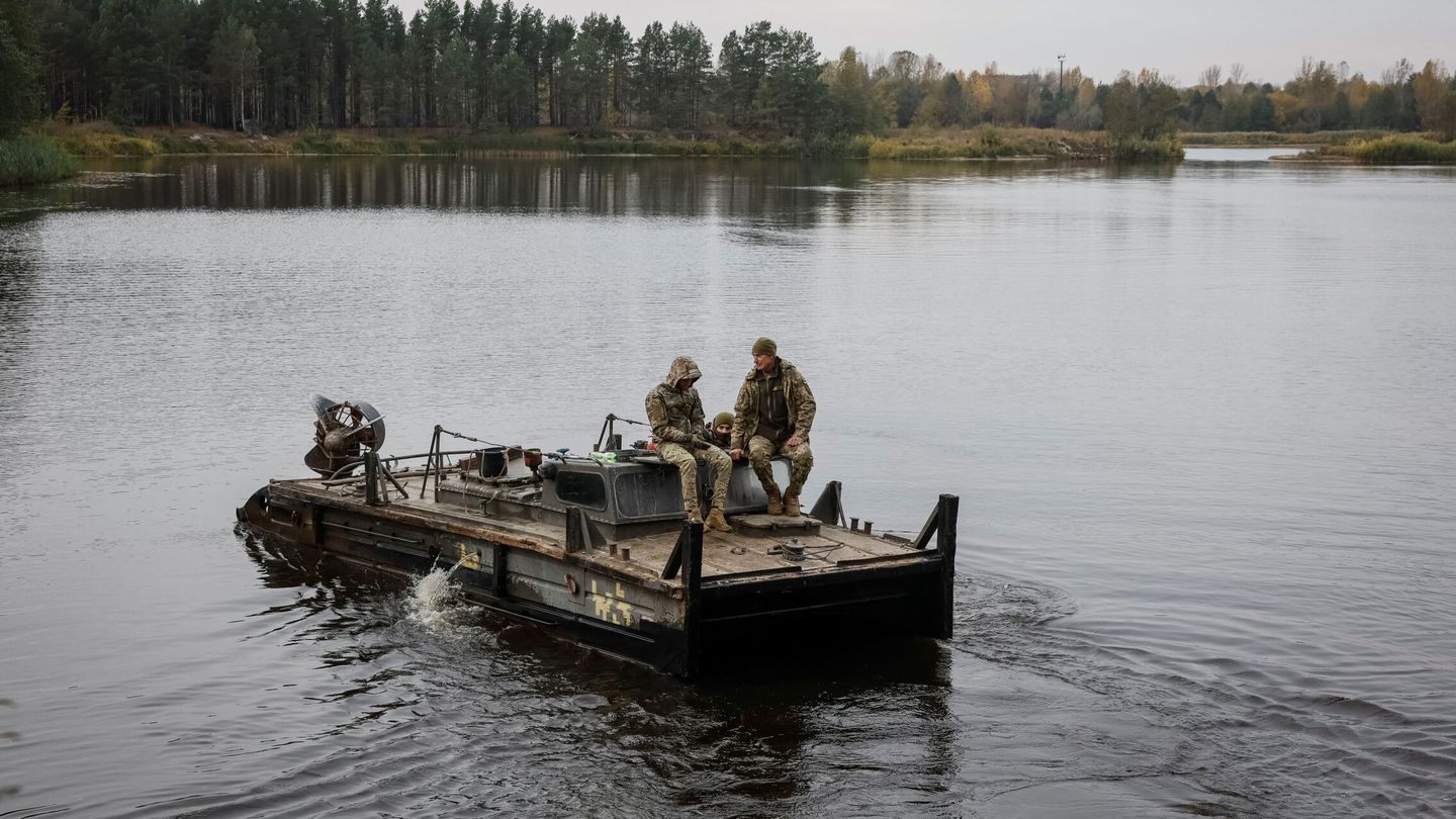 Ukrainian servicemen cross a river near a destroyed bridge as they deliver food and medicine to civilians in a Chornobyl exclusion zone village from which the locals were evacuated in 1986 around the Chornobyl nuclear power plant near a Belarus border, amid Russia's attack on Ukraine, in Ukraine October 18, 2023. This overgrown wilderness virtually devoid of people where buildings disappeared under a tangle of foliage is still home to a handful of pensioners who have stubbornly resisted leaving and vitally depend on Ukraine's military aid since the bridges were destroyed due to Russia's attack on Ukraine. REUTERS Gleb Garanich
