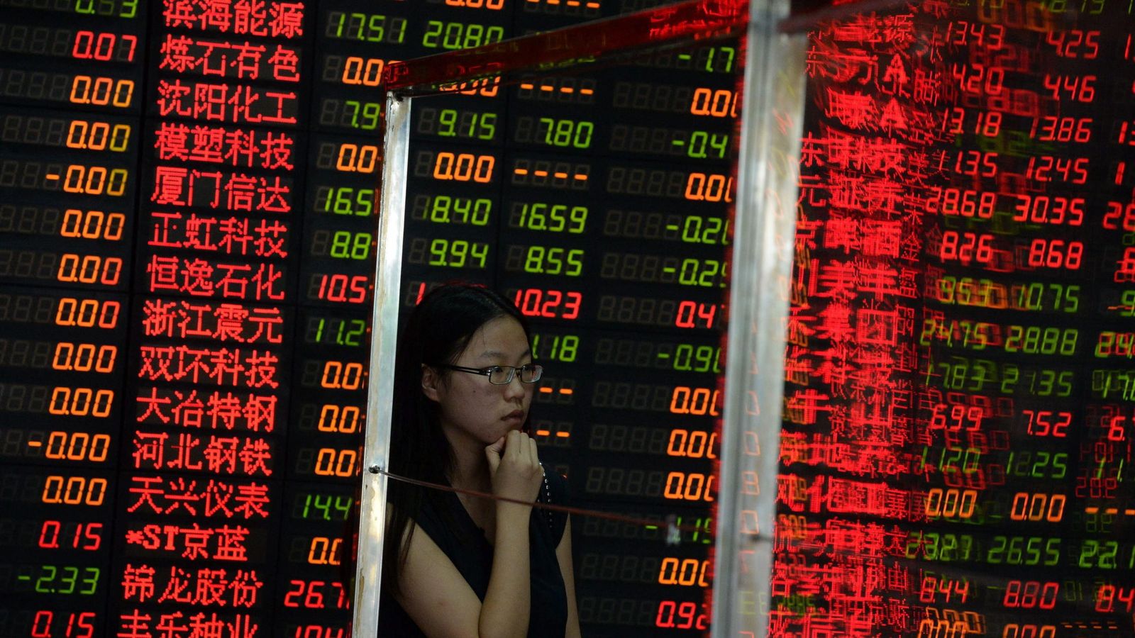 Foto: Una inversora observa una pantalla con información bursátil en una compañía de corretaje en Shanghái. (EFE)