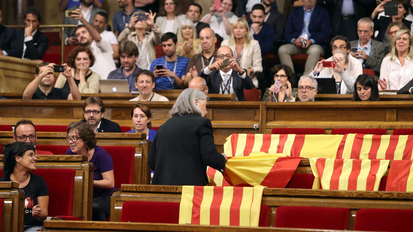 La diputada de Cataluña si que es pot, Angels Martínez, retira banderas de España en el parlamento catalán. (EFE)