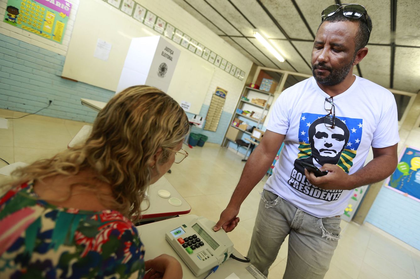 Un hombre con una camiseta de Bolsonaro vota en un colegio electoral en Brasilia. (EFE)