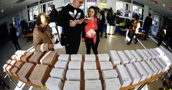 Foto: Tres personas deciden su voto en un colegio electoral. (EFE)