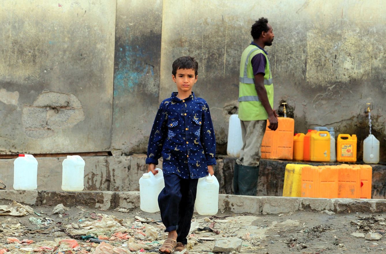 Un niño yemení recoge agua en una fuente pública en Saná (Yemen)