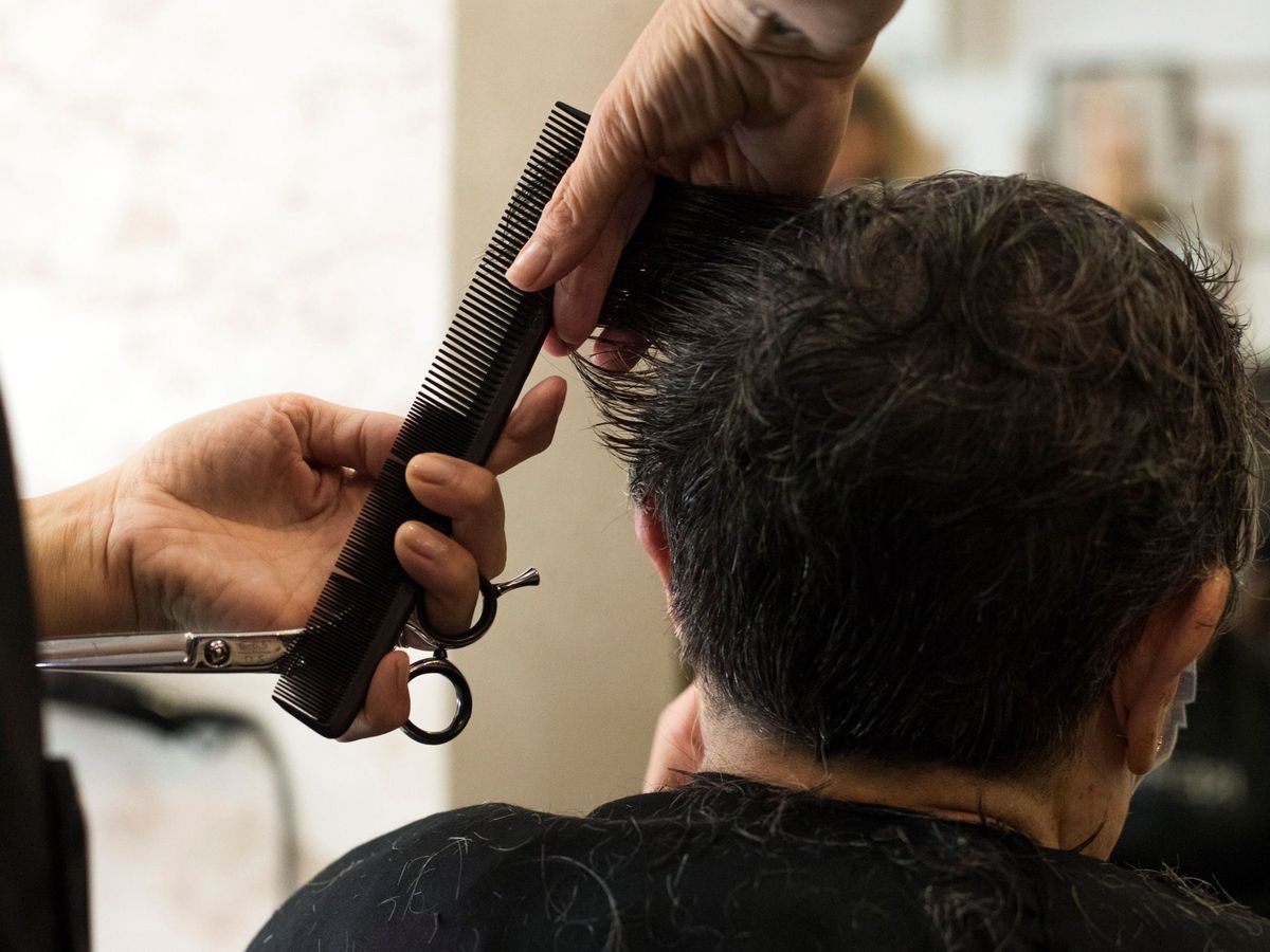 Foto: Un hombre se corta el pelo en una peluquería como las que se suceden en los barrios de Madrid. (EFE/Toni Galán)