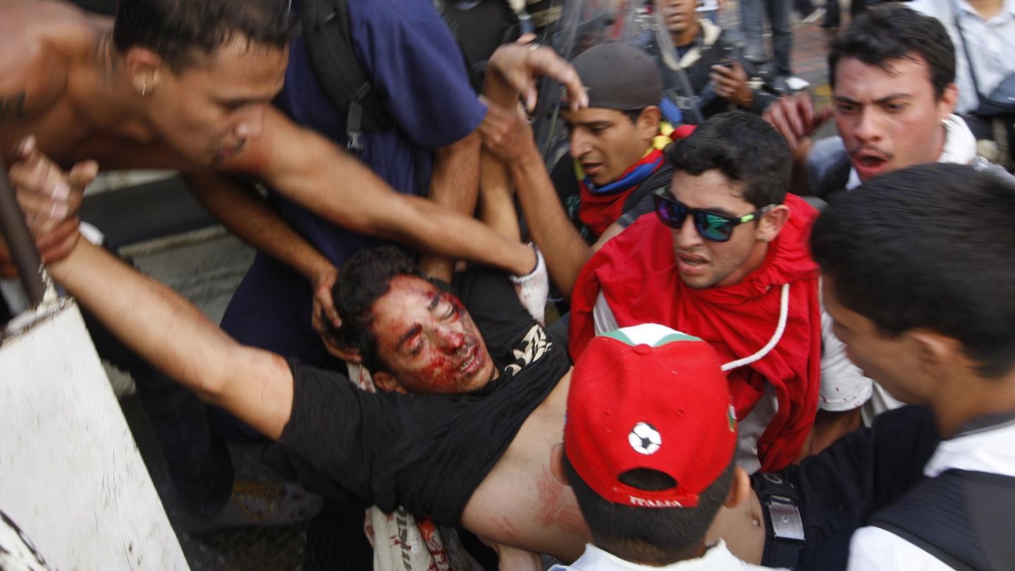 Un muerto tras escucharse disparos durante la marcha en Caracas es evacuado por manifestantes (Reuters).