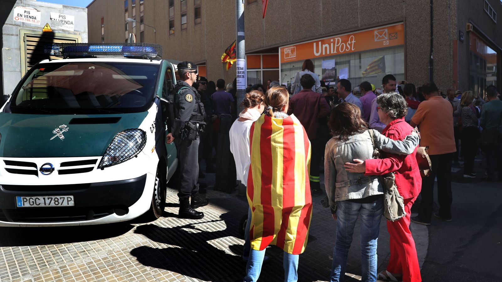 Foto: Numerosas personas permanecen ante la oficina de la empresa de mensajería Unipost en Terrassa. (EFE)