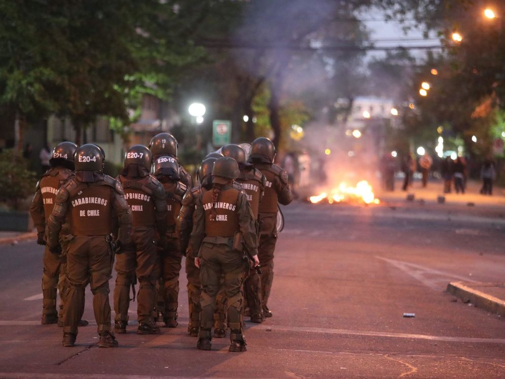 Foto: Carabineros actúan contra manifestantes en una calle del barrio de Providencia, en el este de Santiago (Chile) (EFE)