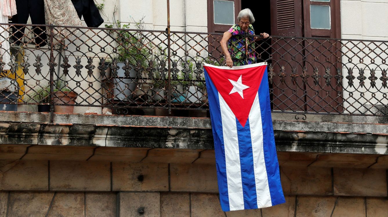 Foto: Una mujer sale al balcón donde se expone una bandera cubana, en La Habana, Cuba. (EFE) 