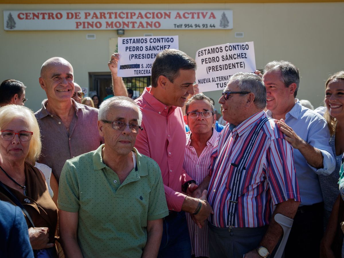 Foto: El presidente Pedro Sánchez saluda a un vecino de Pino Montano flanqueado por Antonio Muñoz y Juan Espadas. (EFE/Julio Muñoz)