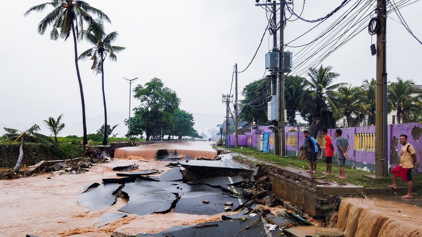 Varias personas observan los daños ocasionados en una carretera en Dili. (EFE)