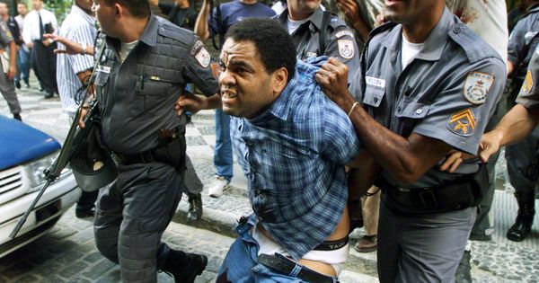 Foto: La policía se lleva a un atracador herido para evitar que la multitud lo linche, en Río de Janeiro, en octubre de 1999. (Reuters) 