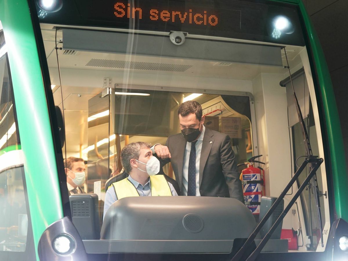 Foto: El presidente de la Junta, Juanma Motreno, dialoga con el maquinista que ha hecho el viaje de prueba del tramo al centro de la ciudad. (Junta de Andalucía)