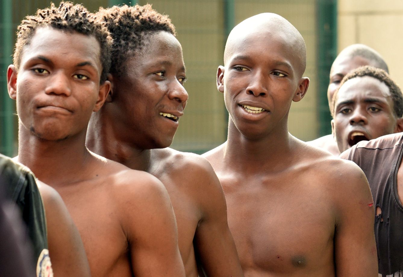 Jovenes migrantes tras saltar la valla (REUTERS)