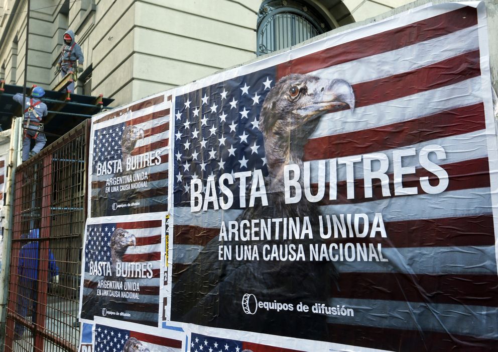 Foto: Trabajadores de la construcción junto a un póster que reza "Basta Buitres. Argentina Unida", el 18 de junio en Buenos Aires. (Reuters).