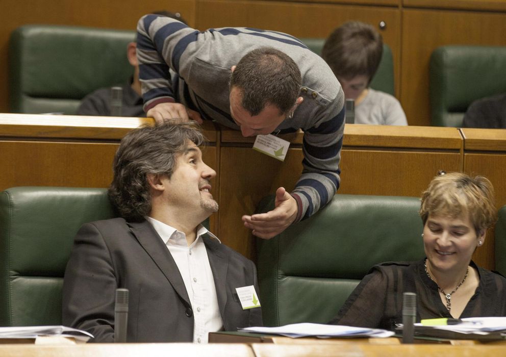 Foto: Los parlamentarios de EH Bildu Peio Urizar (i) y Unai Urruzuno conversan durante un pleno del Parlamento vasco. (Efe)
