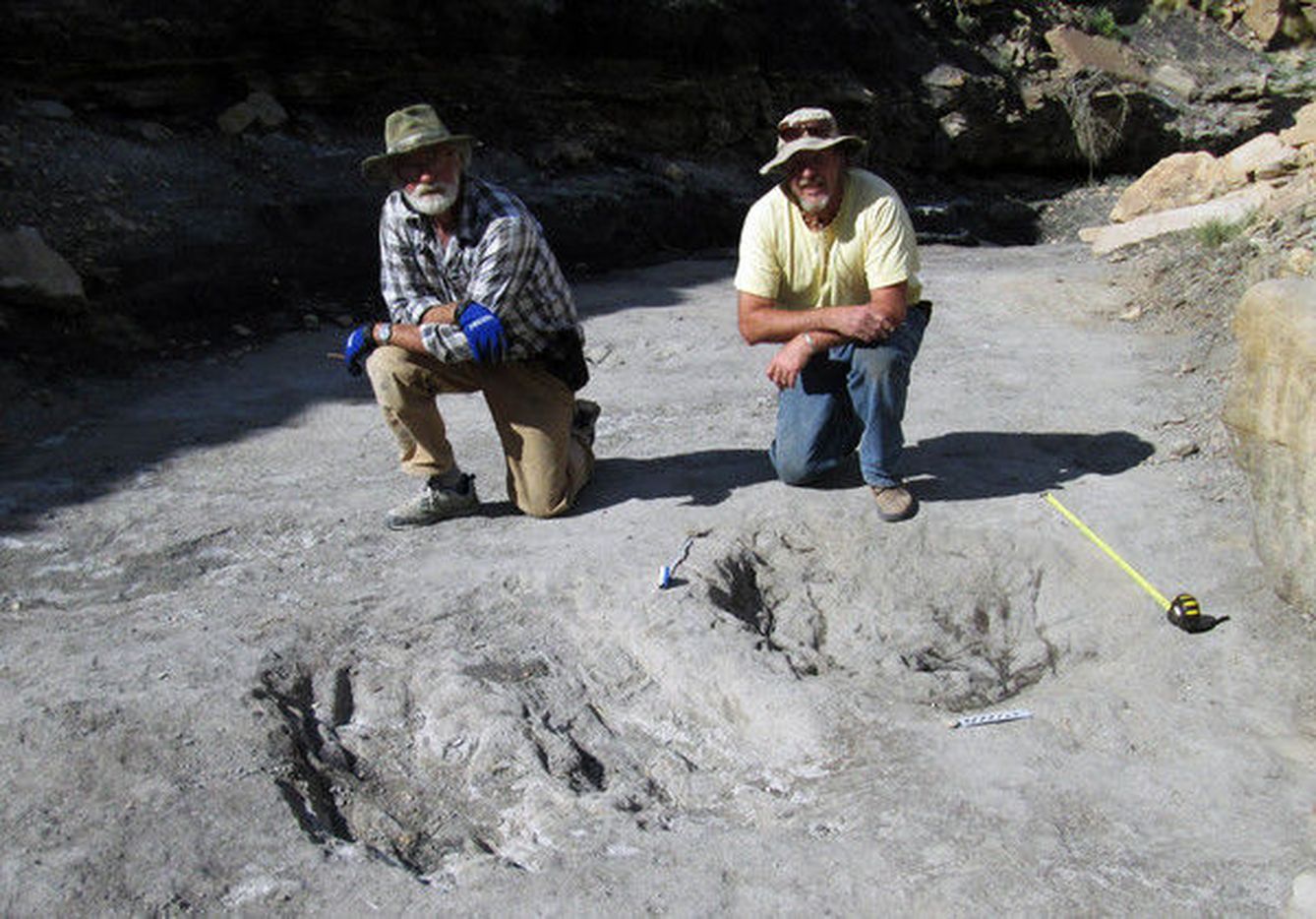 Los investigadores posan junto a los rasguños de dinosaurio descubiertos en Colorado. (Universidad de Colorado)