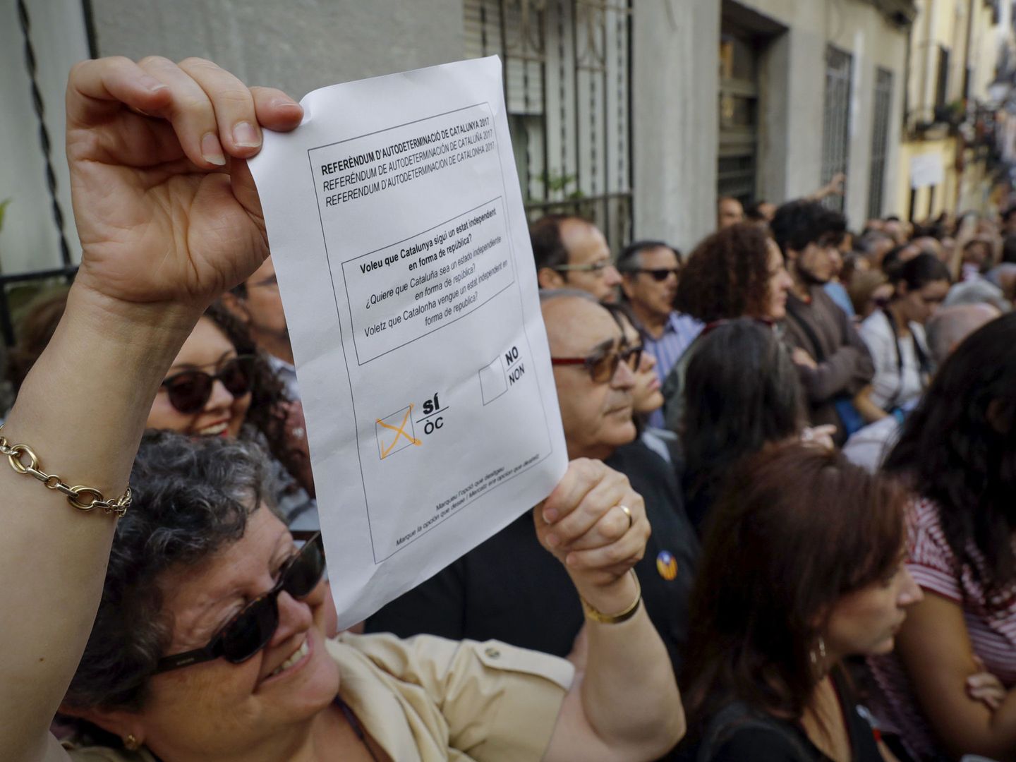 Varias personas a favor del referéndum soberanista en Cataluña asisten al acto. (EFE)