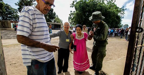 Foto: Una anciana recibe ayuda de un soldado en un colegio electoral en Puerto Ordaz. (Reuters)