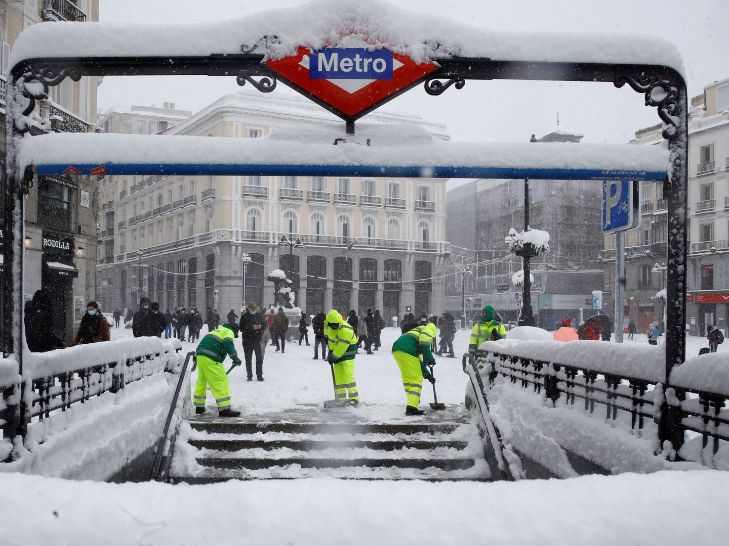 Operarios trabajan para retirar nieve y mejorar la circulación en la Puerta del Sol en Madrid. (EFE)