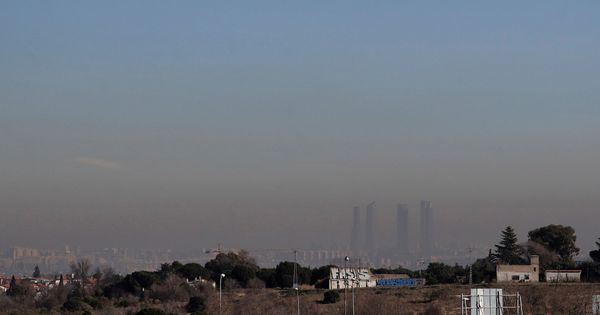 Foto: Imagen de las Cuatro Torres de Madrid bajo una intensa nube de contaminación, este martes en Madrid. (EFE)