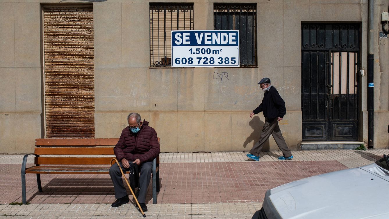 Foto: Dos vecinos de Benavente, junto a uno de los tantos carteles de 'se vende'. (Emilio Fraile)