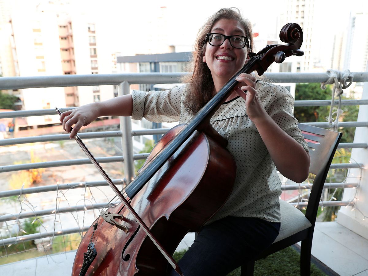 Foto: Una chelista uruguaya toca para sus vecinos en el balcón. (Reuters)
