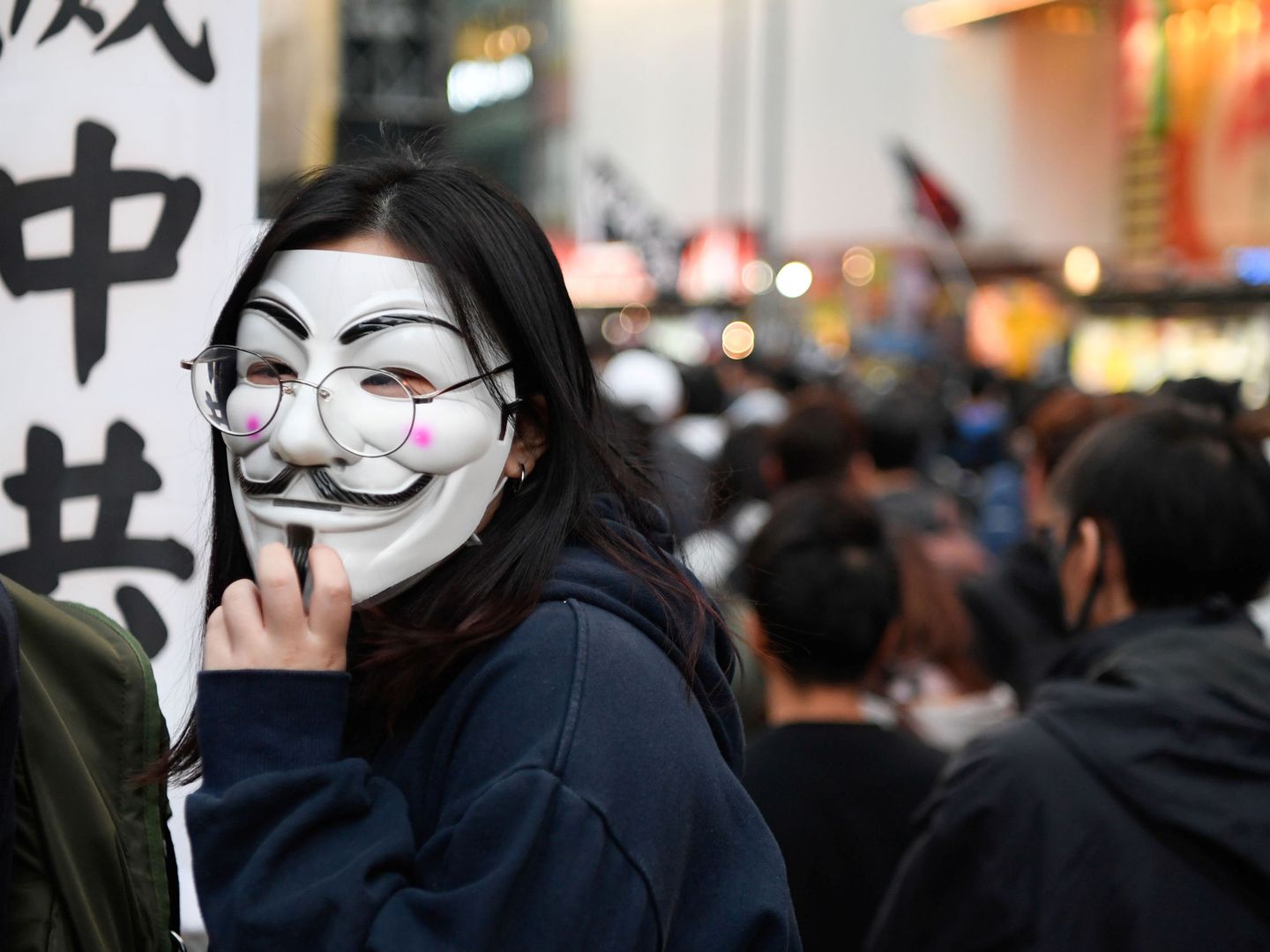 Otro manifestante con una máscara ondea una bandera durante la marcha. (Reuters)