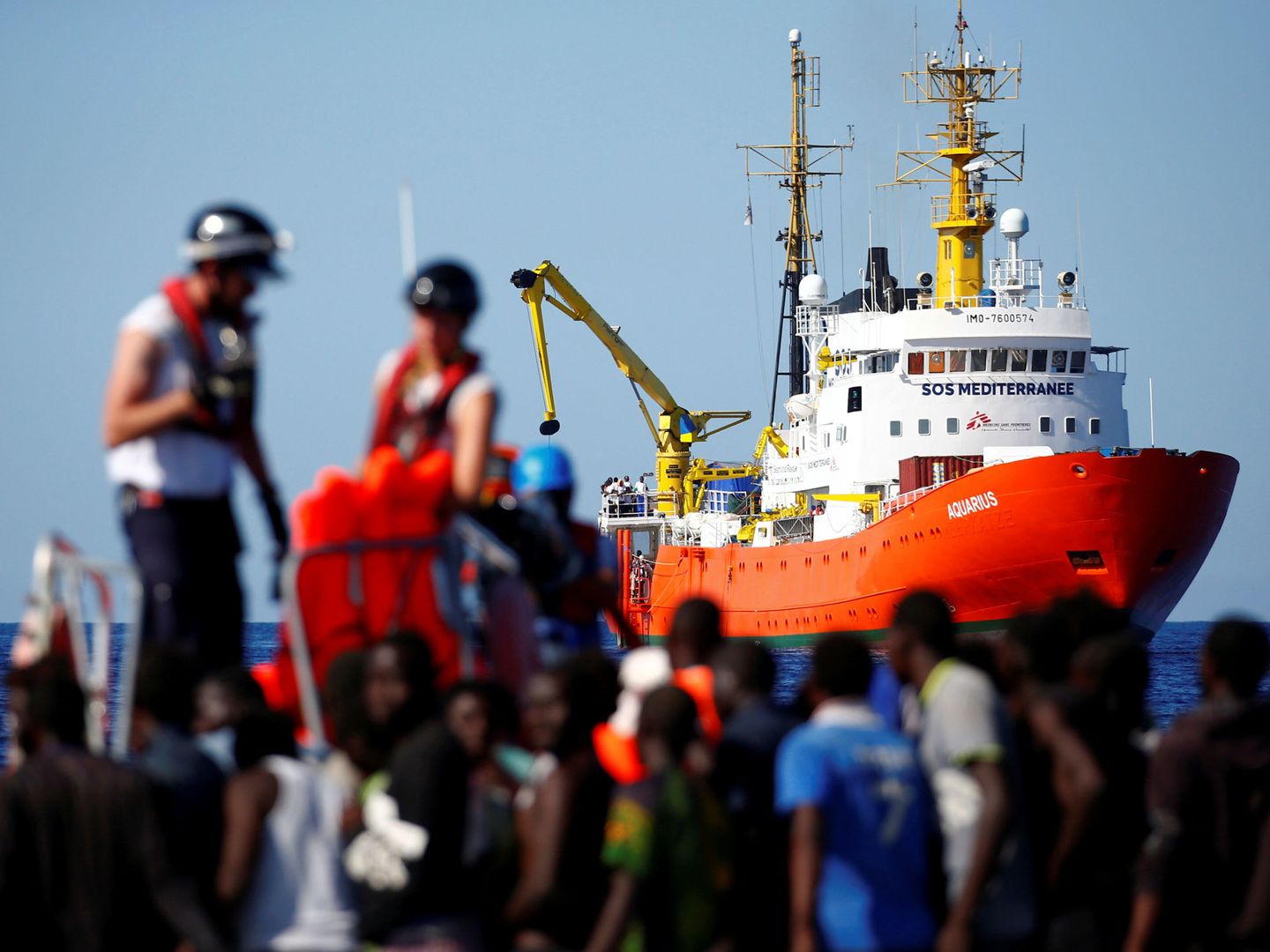 Migrantes rescatados por la ONG SOS Mediterranée esperando para embarcar en el Aquarius. (Reuters)