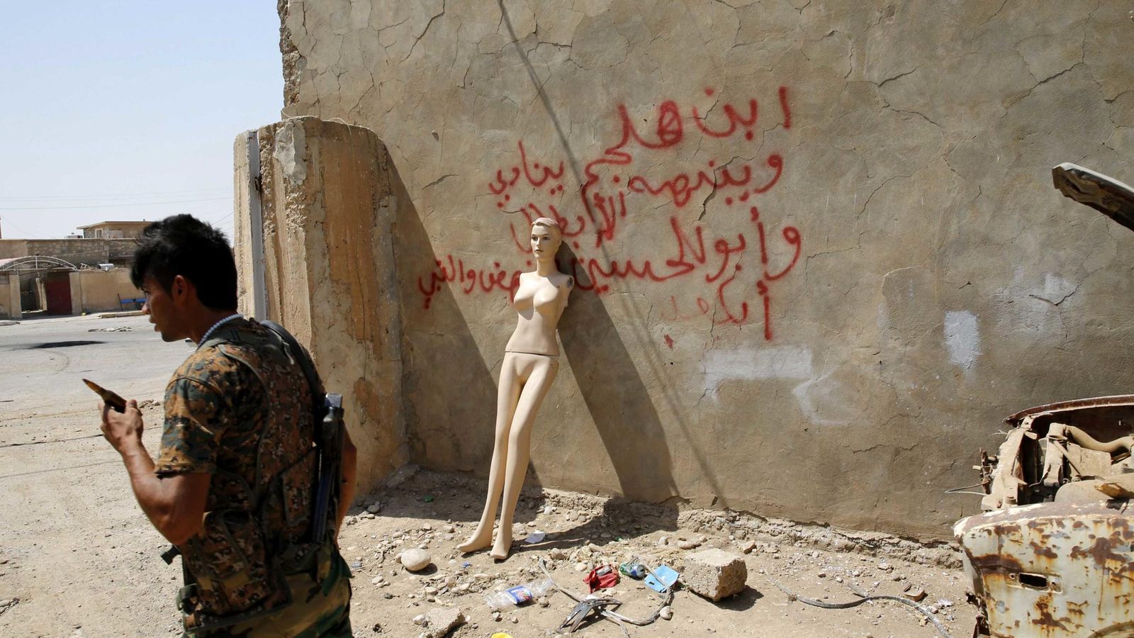 Foto: Un combatiente peshmerga frente a un maniquí, en una base conquistada al Estado Islámico (Reuters)