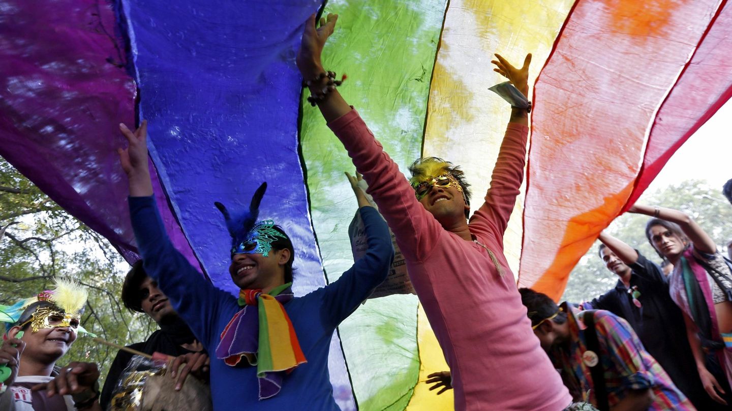Participantes en el Gay Parade de Nueva Delhi bailan bajo una bandera multicolor (Reuters). 