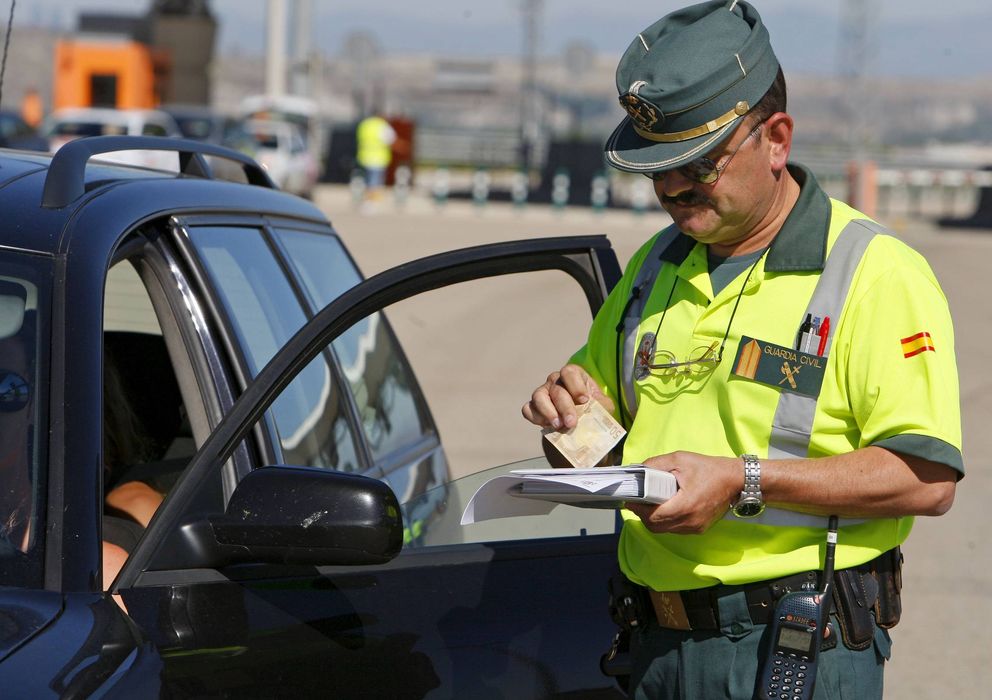 Foto: Un agente pone una multa tras un control de velocidad (Efe)