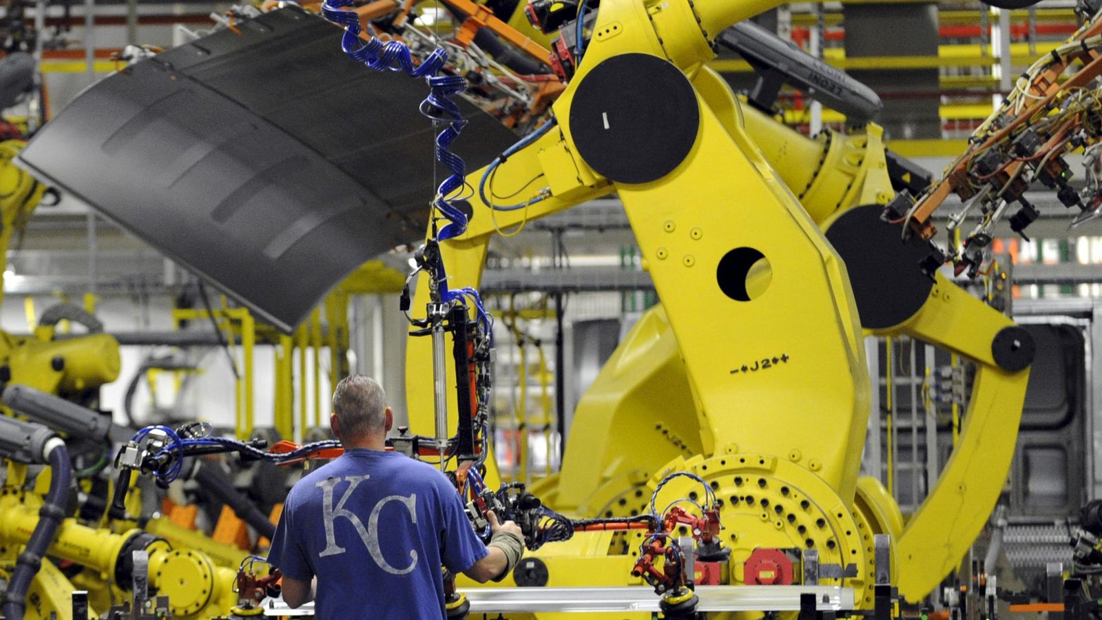 Foto: Un empleado y un robot, en la fábrica de Ford en la ciudad de Kansas.
