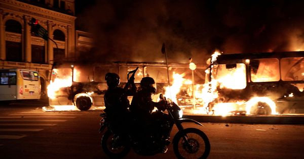 Foto: Policías antidisturbios pasan frente a unos autobuses en llamas en Rio de Janeiro, el 28 de abril de 2017. (Reuters)