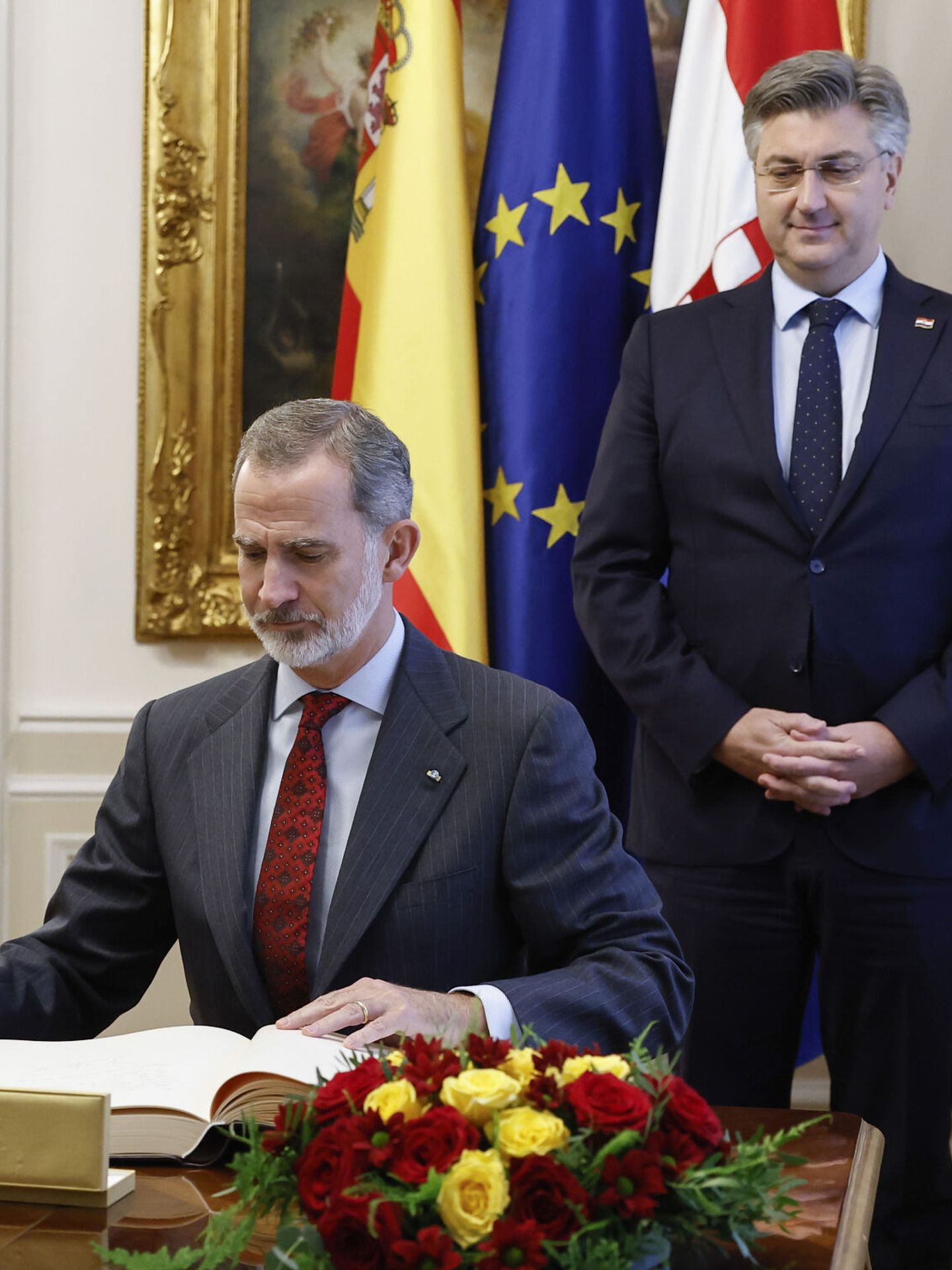 El Rey firma en el libro de honor en presencia del primer ministro croata. (EFE/Chema Moya) 