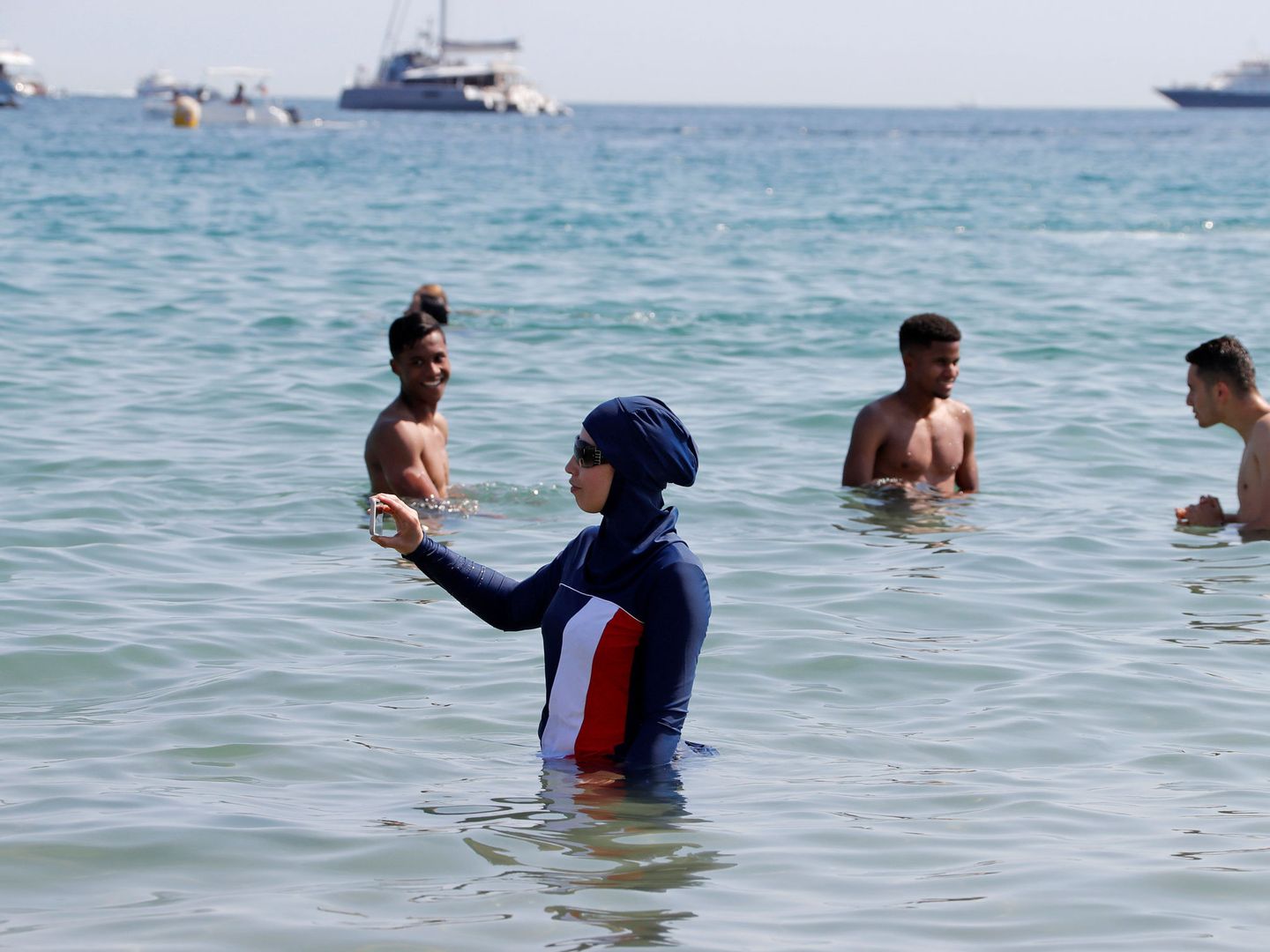 Una joven en burkini se hace un selfie en una playa de Cannes, en 2017. (Reuters)