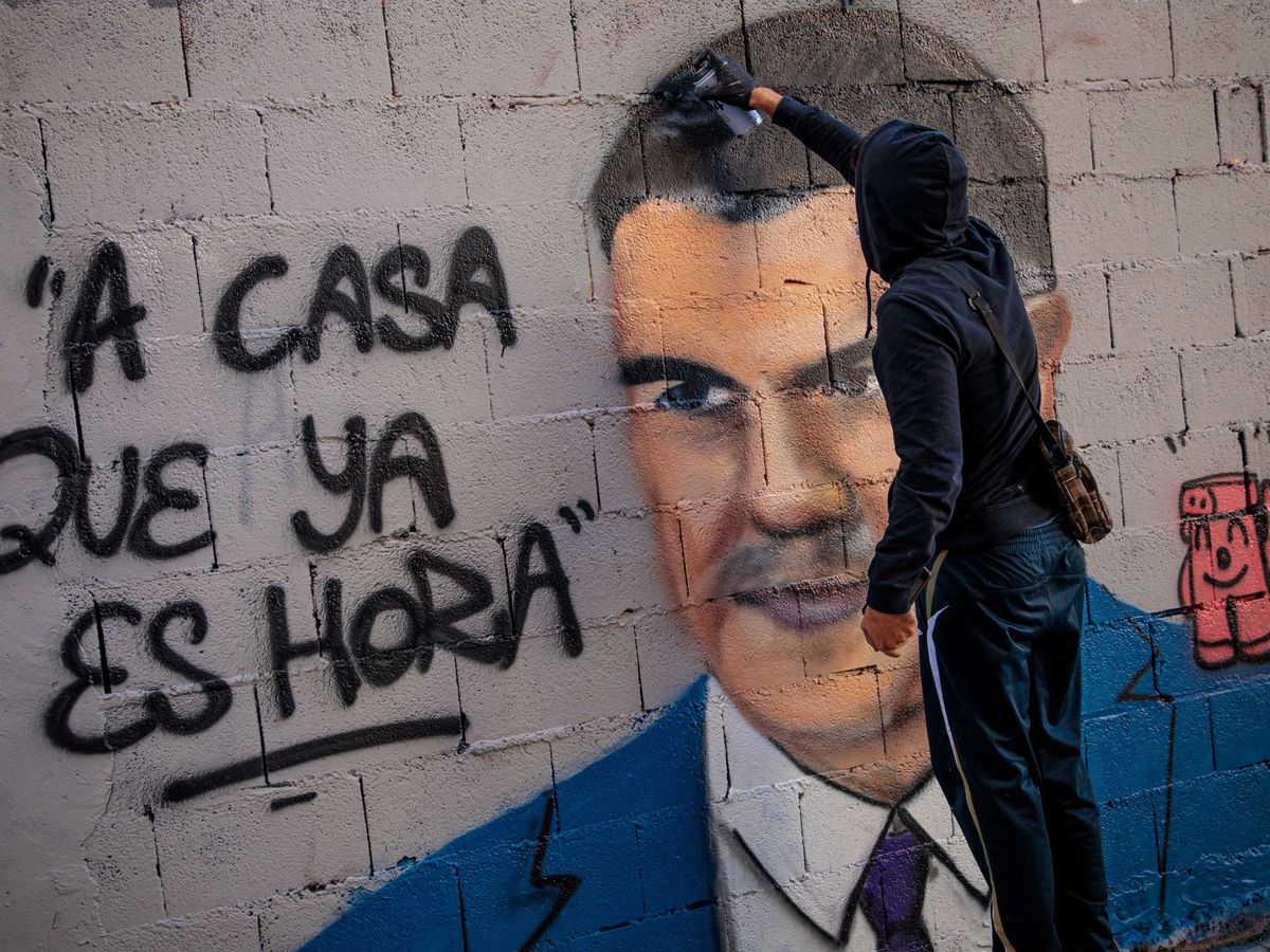 Foto: El artista urbano J. Warx realiza un grafiti en Valencia en relación a la pandemia de covid-19. (EFE) 