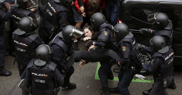 Foto: Agentes de la Policía forman un cordón policial en el colegio Ramón Llull y se llevan a una chica. (EFE)